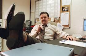 David Brent from The Office sits at his desk over confidently.